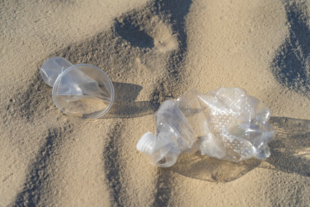 Plastic pollution in the environmental problem of the world. A hand in a white glove puts garbage in...