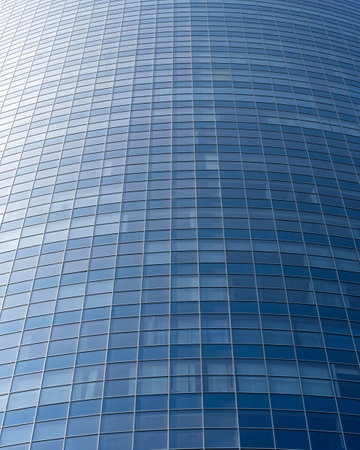 modern office building facade. Tall business center with a glass facade. Construction of a glass facade structure. The glare of the sun on the glass wall of a skyscraperの写真素材