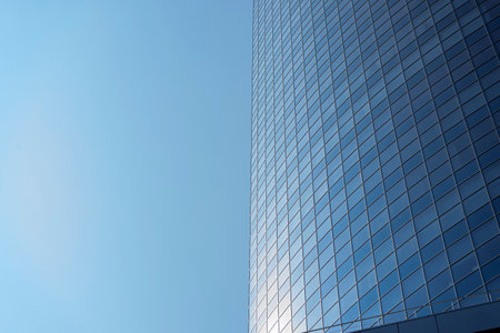 modern office building facade. Tall business center with a glass facade. Construction of a glass facade structure. The glare of the sun on the glass wall of a skyscraperの写真素材