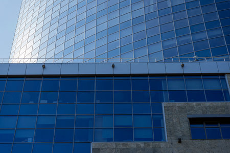 modern office building facade. Tall business center with a glass facade. Construction of a glass facade structure. The glare of the sun on the glass wall of a skyscraperの写真素材