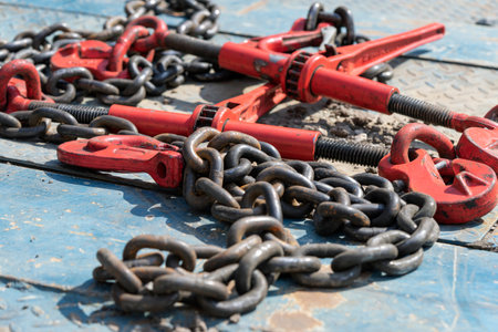 Crane hook, on which chains with hooks and fastening elements are attached. Lifting mechanism in production and warehouse close-up.の写真素材