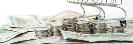 Money, US dollar bills background. Paper money is scattered on the table with silver coins. Photo...