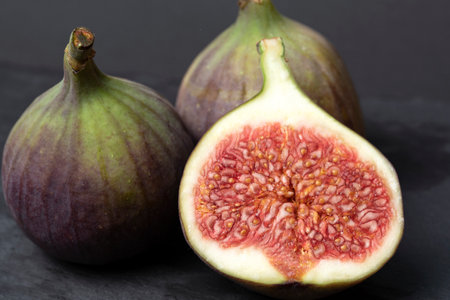 Figs cut into pieces on a black background close-up