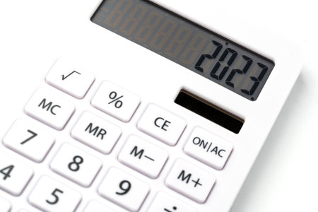 A white calculator with 2023 on the screen. A concept for recording income, expenses and controlling...