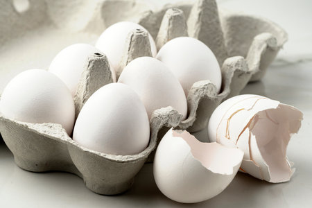 Close-up of lots of raw whole white chicken eggs for cooking fresh homemade food.