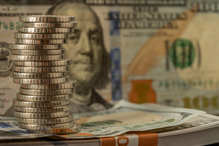Money, US dollar bills background. Paper money is scattered on the table with silver coins. Photo...