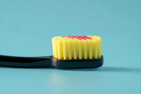 New toothbrush with toothpaste closeup on blue background closeup