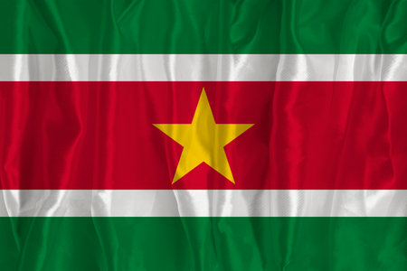 The flag of Suriname on a silk background is a great national symbol. Texture of fabrics The official state symbol of the countryの写真素材