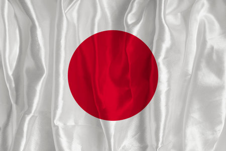 The flag of Japan on a silk background is a great national symbol. Texture of fabrics The official state symbol of the countryの写真素材