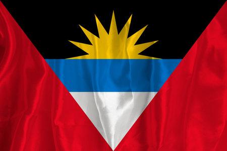The flag of Antigua on a silk background is a great national symbol. Fabric texture The official state symbol of the country. flag backgroundの写真素材