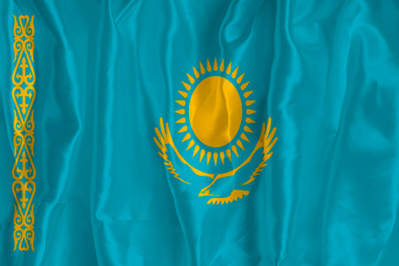 The flag of Kazakhstan on a silk background is a great national symbol. Texture of fabrics The official state symbol of the countryの写真素材