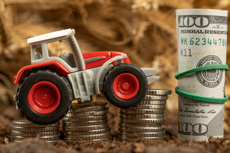 Tractor with money on the background of spikelets of wheat. Export of grain and agriculture. Rising prices for agricultural productsの写真素材