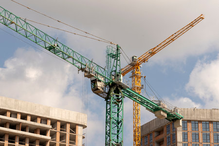 tower cranes at construction site and city backgroundの写真素材