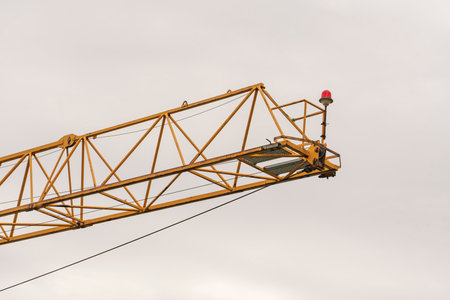 Crane and construction site against the blue sky. Working on large construction sites, and many...