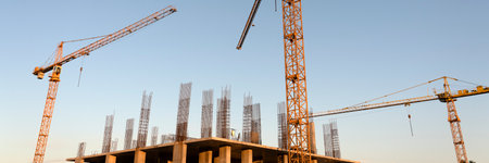 tower cranes at construction site and city backgroundの写真素材