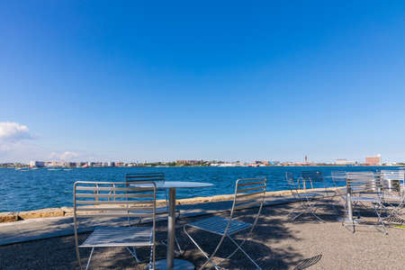 Tables with umbrellas on sunny day at Fan Pier Park Boston, Massachusetts.  Close to seaの写真素材