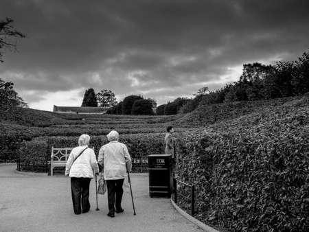 Two ladies walking and talking by garden labyrinths of Kensigntonのeditorial素材