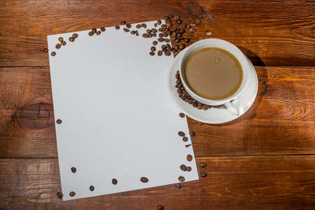 cup of coffee with white paper on a background of dark woodの写真素材