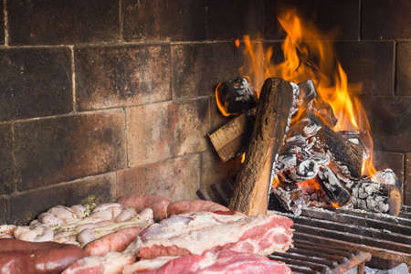 Barbecue. Meat cuts warming on the embers on an iron grill. Traditional Argentinian bbq.の写真素材