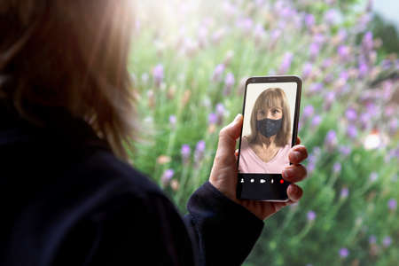 Two women talking to each other through a video call on a smartphone. Senior woman having a video...