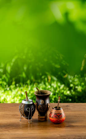 Three traditional mates made of calabash over a wooden table outdoors. Culture of south america. Copy space for design. Vertical format.の写真素材