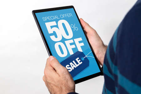 Man holding a tablet with 50% off sale adversiting on the screen. White background.