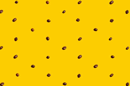 Coffee beans organized and forming a texture over yellow background.