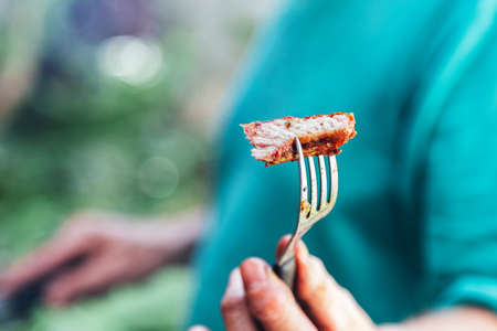 Man offering a piece of meat roasted with a fork.の写真素材