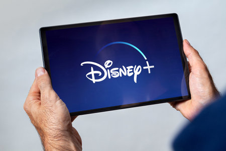 Tablet with Disney Plus video streaming service logo on the screen. ORLANDO, FLORIDA - APRIL 8,...