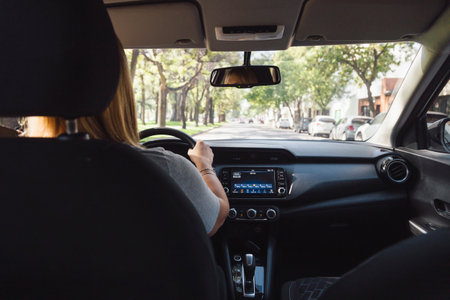 Woman driving a modern car through the city. Inside view.の写真素材