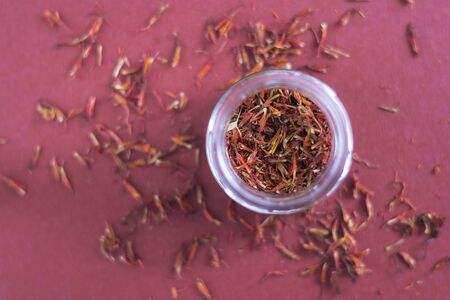 Small jar of saffron on a red backgroundの写真素材