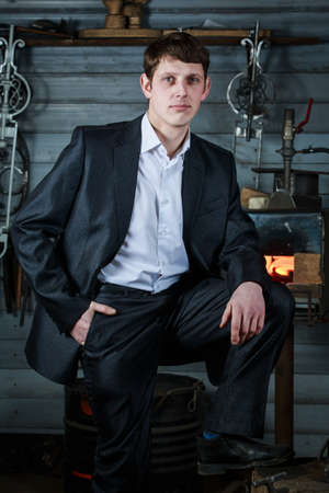 A confident young man in a strict suit in the smithyの写真素材