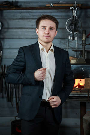 confident young man in a strict suit in the smithyの写真素材