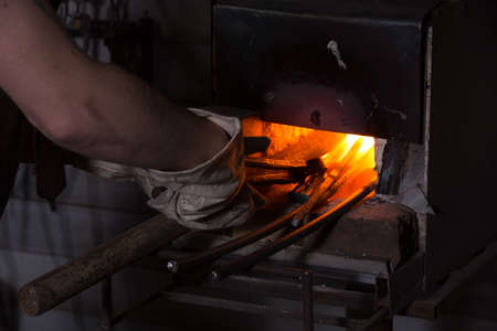 About artistic Forging of Metal. Blacksmithing. Pattern and forms for the artist blacksmith. Treatment of molten metal close-up. Handmade blacksmith.の写真素材