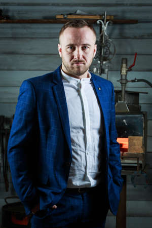 young handsome businessman in a strict suit is working in his forge