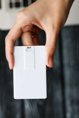 Blank white plastic wafer usb card design mockup holding hand. Visiting flash drive namecard mock up.Call-card disk souvenir presentation. Flat wallet credit stick adapter.の写真素材