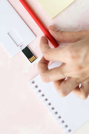 Portable flash drive card or bussines card, notebook, pen, on pink background.mock upの写真素材