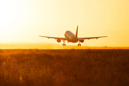 Airplane preparing for landing during sunrise.の写真素材