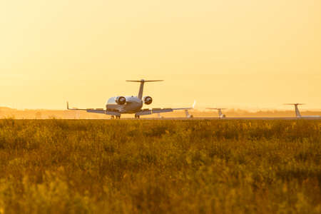Airplane preparing for landing during sunrise.