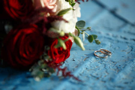 wedding bouquet with red roses lies on a blue backgroundの写真素材