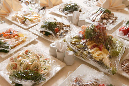 Table setting for an event party or wedding reception.A beautiful banquet table with snacks and bouquet on the tableの写真素材