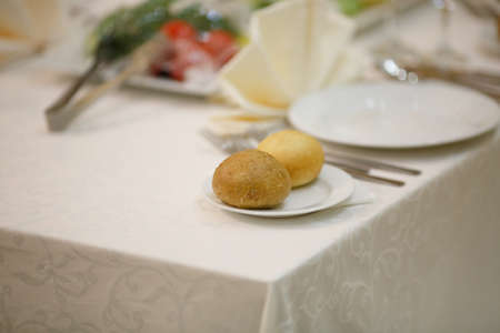 Table setting for an event party or wedding reception.A beautiful banquet table with snacks and bouquet on the tableの写真素材