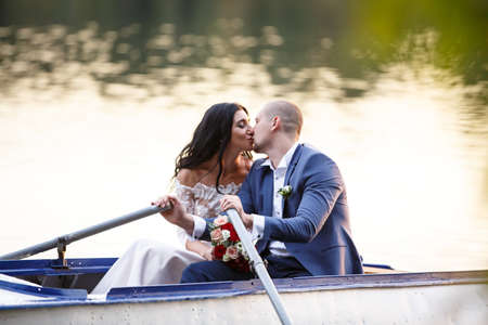 Portraits of a newly married couple. The wedding couple is kissing, hugging on the background of the order. Lovers are happy.の写真素材