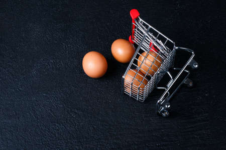 Shopping cart full of eggs, isolated on black backgroundの写真素材