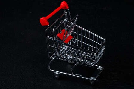 toy mini muniature shopping cart, grocery trolley on black dark background