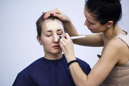 Backstage scene: Professional Make-up artist doing glamour model makeup at workの写真素材