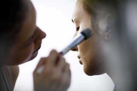 Backstage scene: Professional Make-up artist doing glamour model makeup at workの写真素材