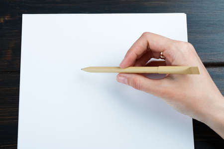 Closeup image of hand writing down on a blank. mockup Top view of female hands making some notes ...