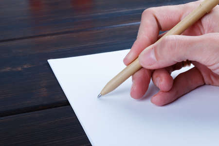 Closeup image of hand writing down on a blank. mockup Top view of female hands making some notes  work, studying, shopping, blogging concept. Mock up, copy space for your text.の写真素材