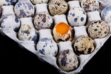 Overhead view of fresh quail eggs in wooden box over purple background Top view with copy space....